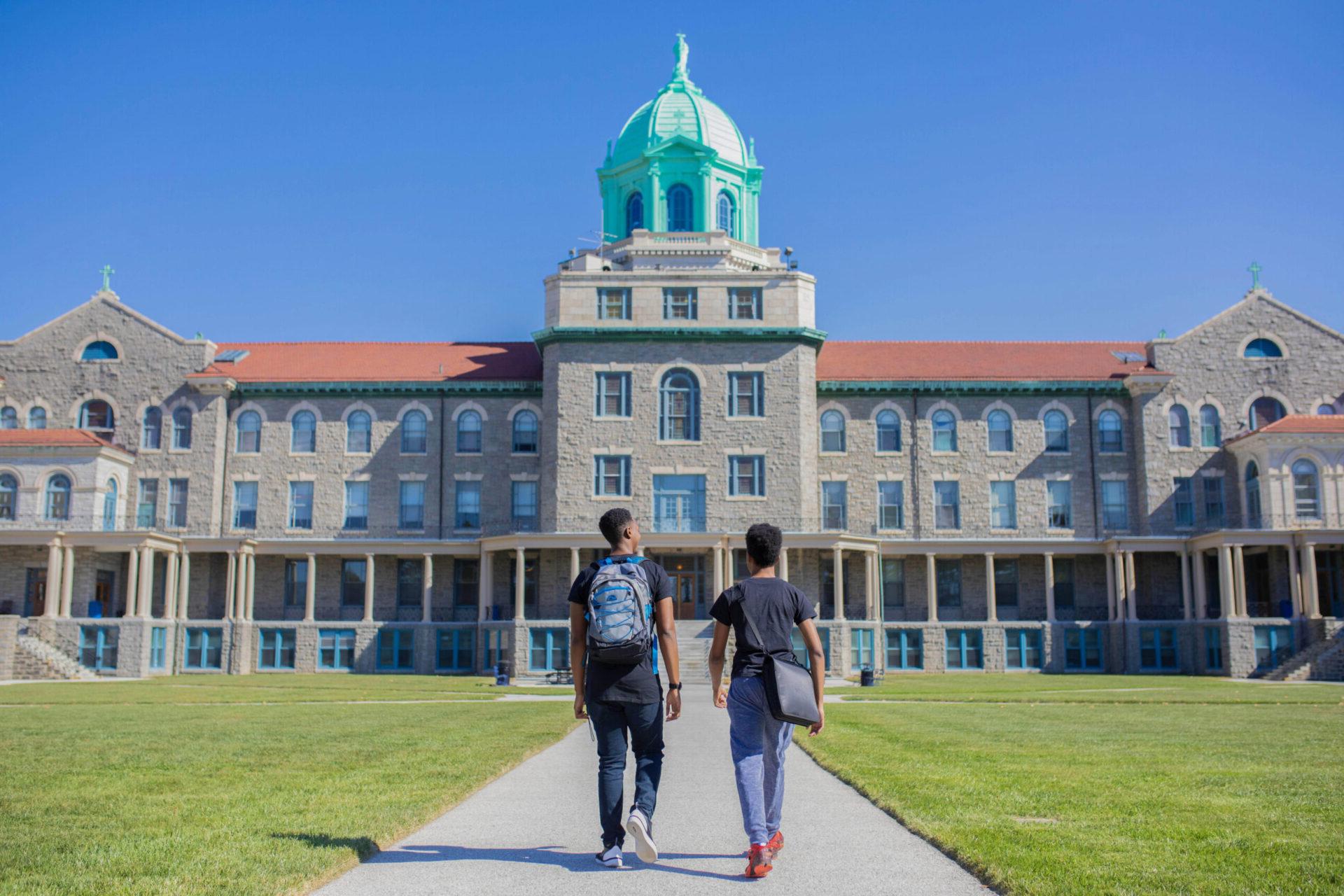 两个学生走在大学大楼前
